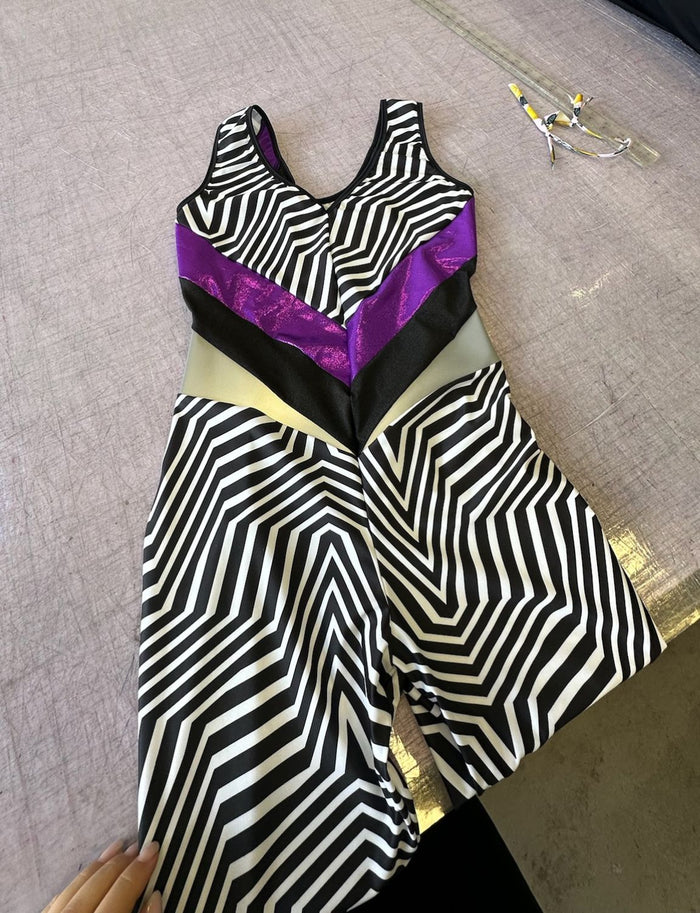 Black and white patterned lycra catsuit with purple panels.