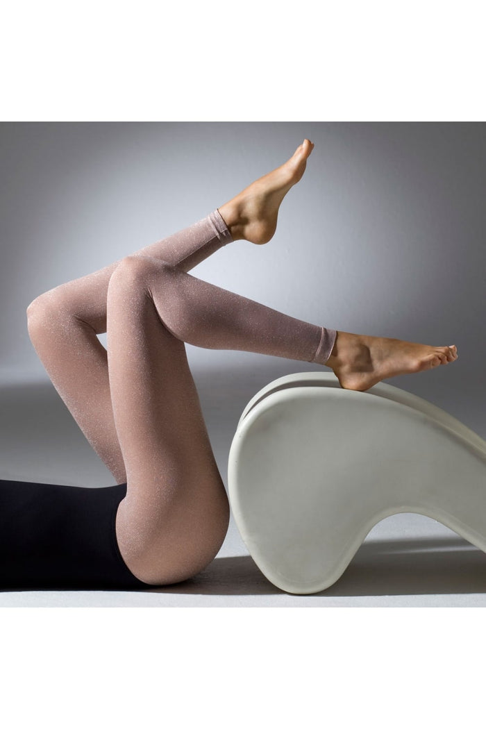 Model wearing blush glitter footless tights with a neutral background