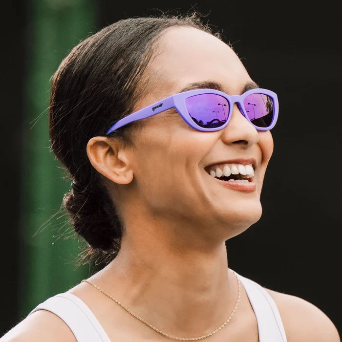 Fit and style showcase of deep purple sunglasses with a cat-eye shape. Purple reflective lenses.