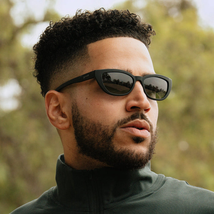 Fit and style showcase of black sunglasses with dark, gradient lenses. Simple and stylish cat-eye frames.
