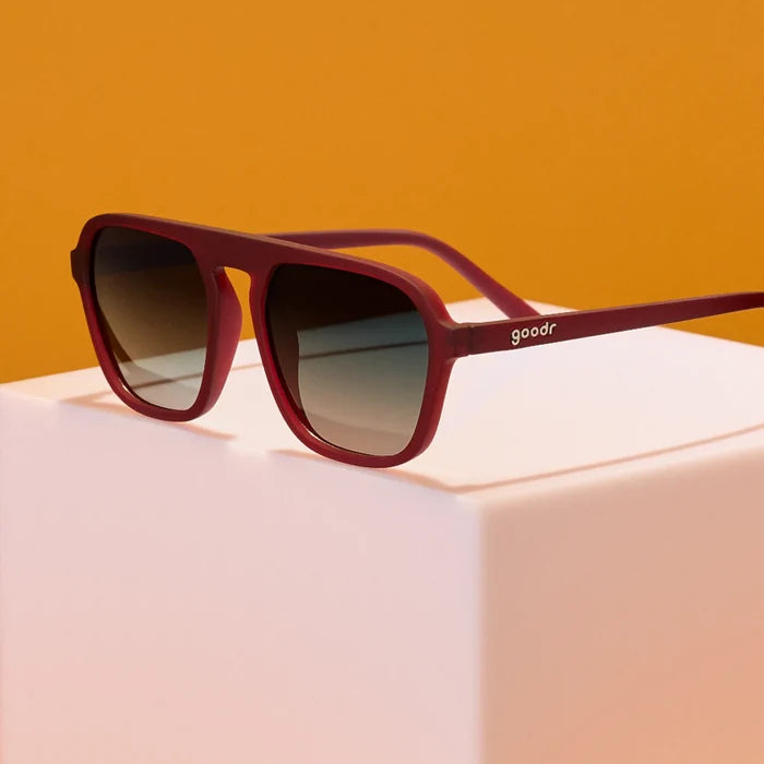 Product close up of brown aviator style sunglasses with green gradient lenses.
