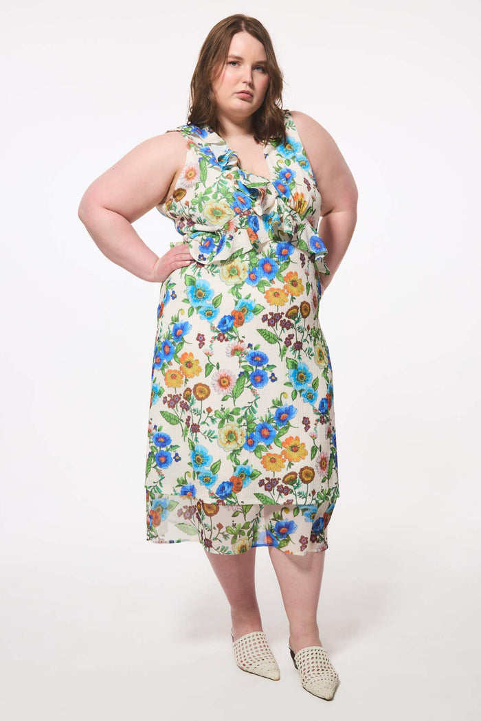 Plus size woman wearing a floral wedding guest dress that was made in Canada on a white background