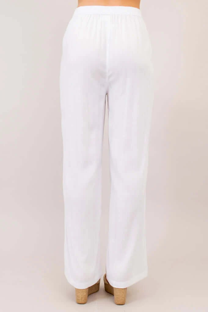 White wide-leg pants on a beige background