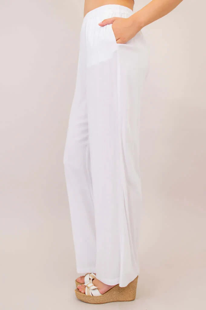 White pants worn by a person on a plain background