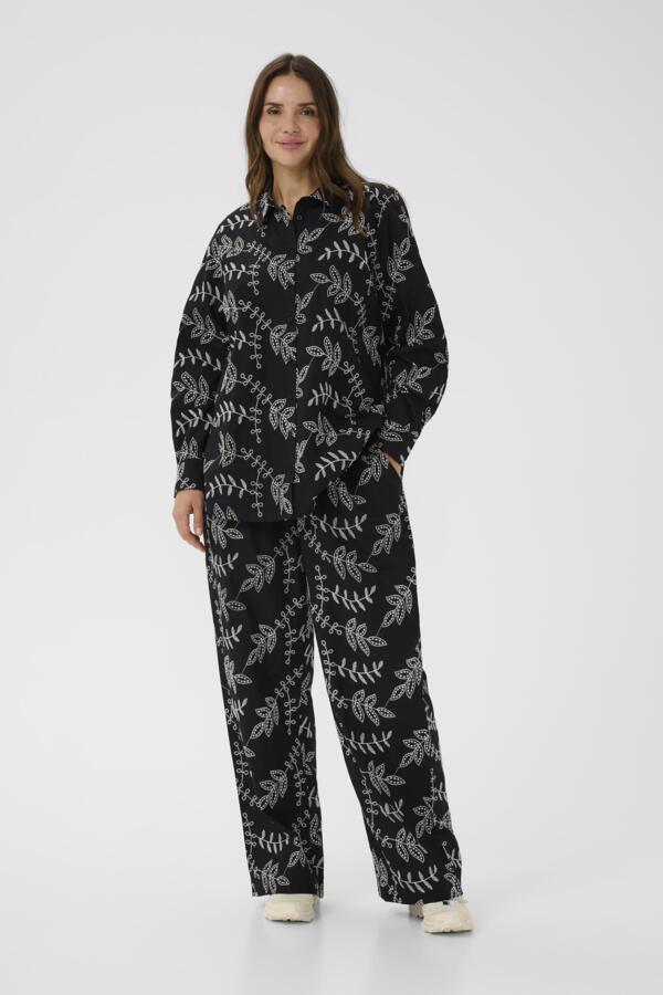 Woman wearing a black floral patterned outfit on a white background