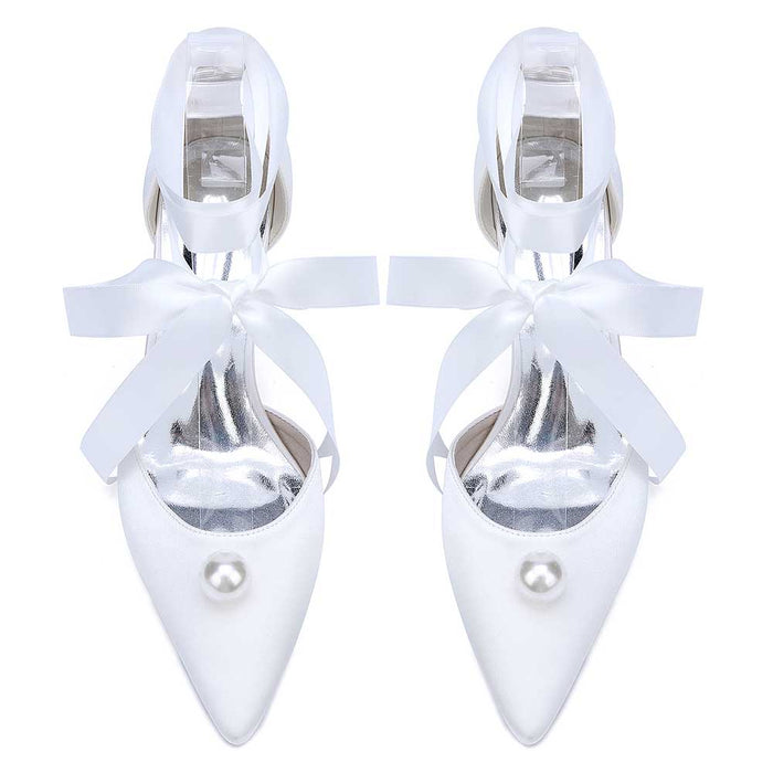 Elegant white bridal ankle strap heels with pearls and satin ribbons for a perfect wedding look