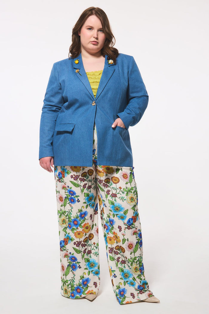 Plus size person wearing a blue blazer and floral pants on a white background