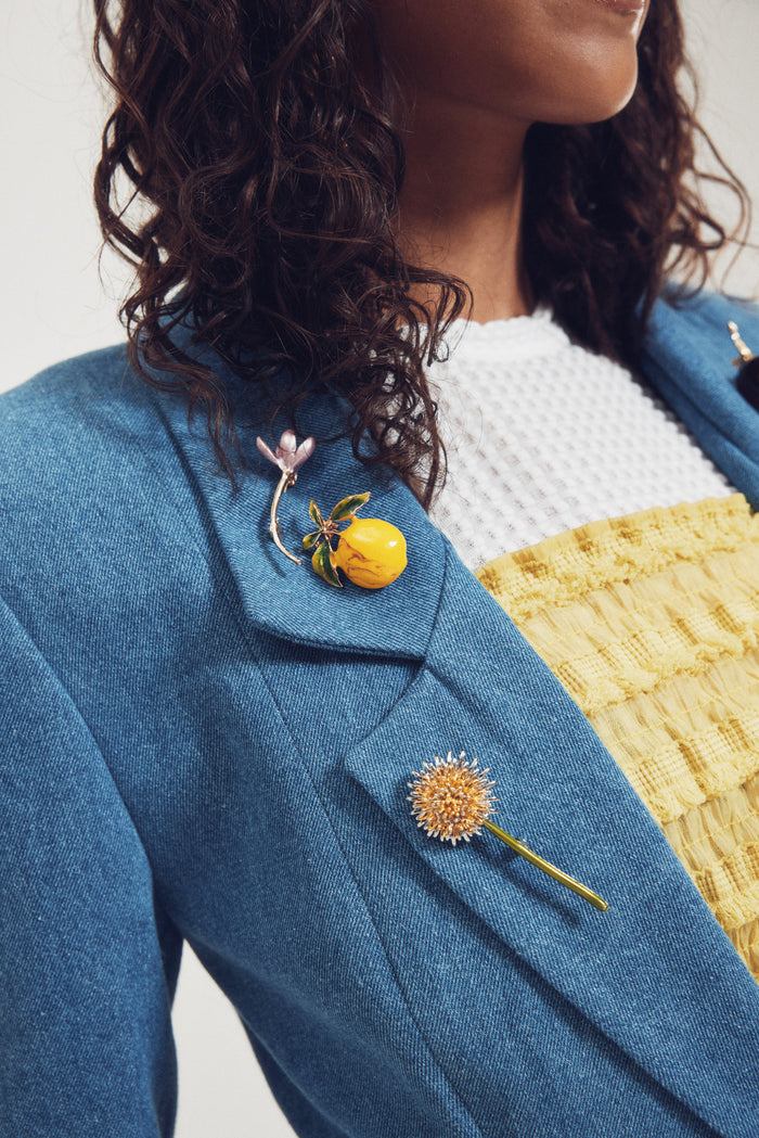Person wearing a blue blazer with floral pins