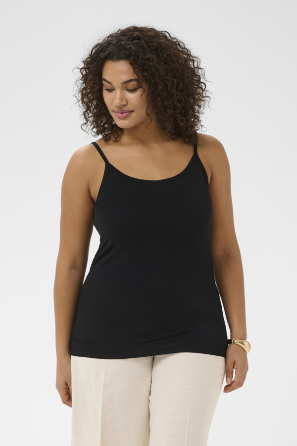 Woman wearing a black tank top and beige pants on a white background
