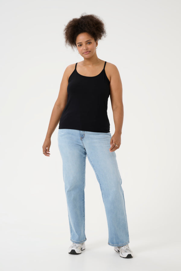 Woman wearing a black tank top and light blue jeans on a white background