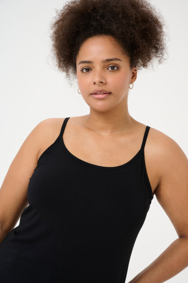 Woman wearing a black tank top against a white background