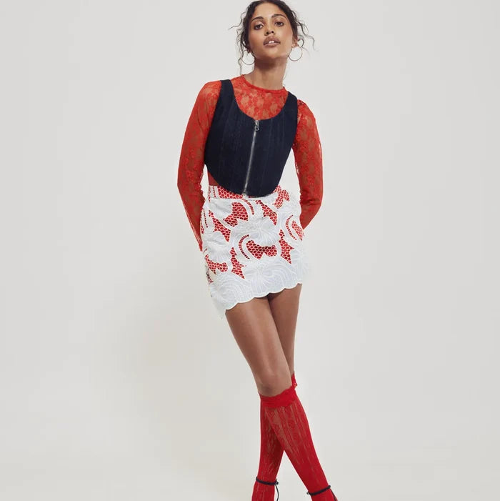 Woman wearing a red and denim outfit with a white background