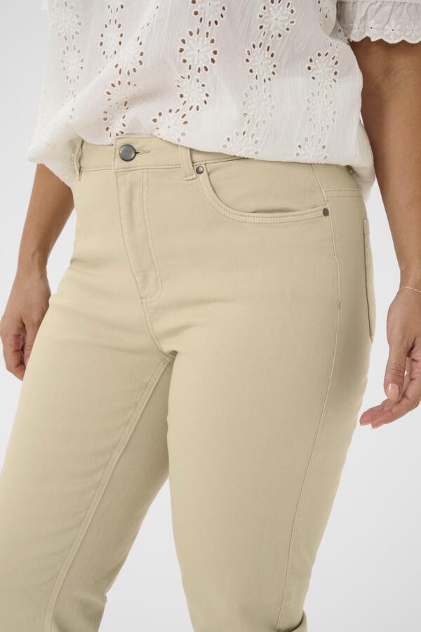 Beige pants worn by a person on a white background