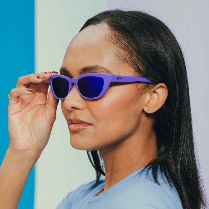 Fit and style showcase of deep purple sunglasses with a cat-eye shape. Purple reflective lenses.