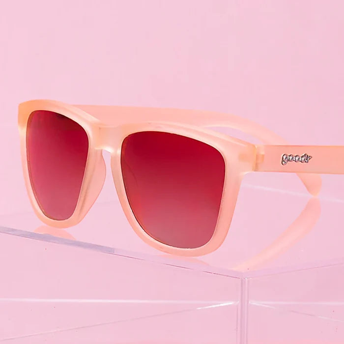 Product close up of pink square-shaped sunglasses with pink gradient lenses.