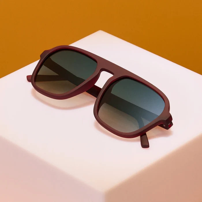 Product close up of brown aviator style sunglasses with green gradient lenses.
