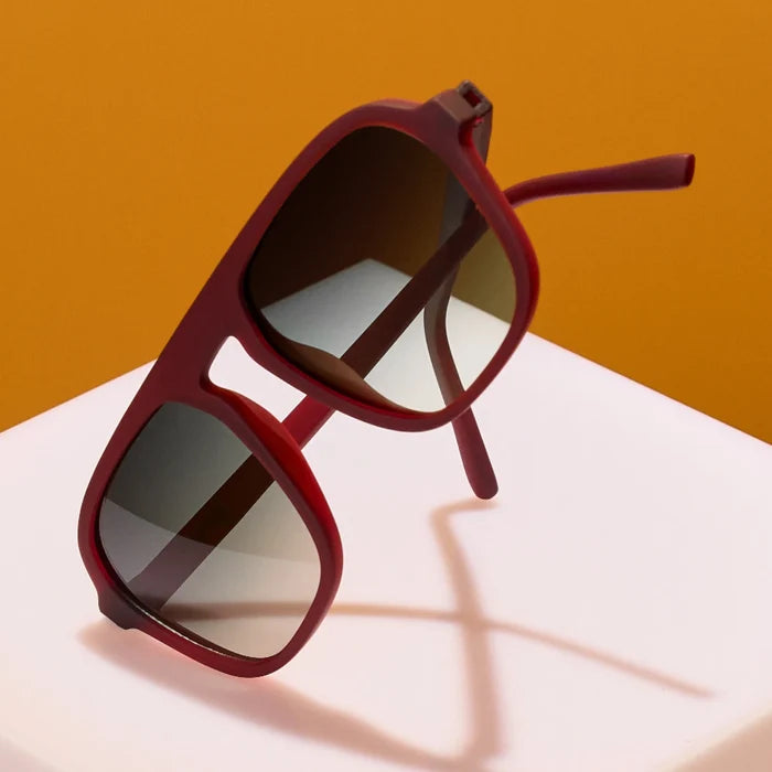 Product close up of brown aviator style sunglasses with green gradient lenses.