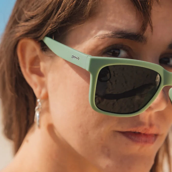 Fit and style showcase of dark green polarised sunglasses with non-reflective lenses. Water repellent and capable of floating.