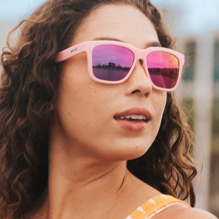 Fit and style showcase of pink sunglasses with mirrored reflective lenses. Water repellent and capable of floating.