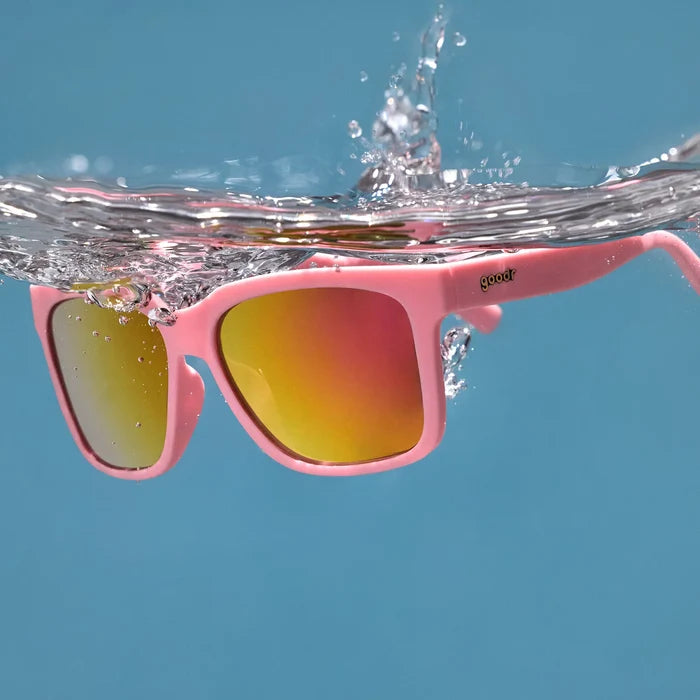 Pink water repellent sunglasses with mirrored reflective lenses. Showcasing ability to float in water.