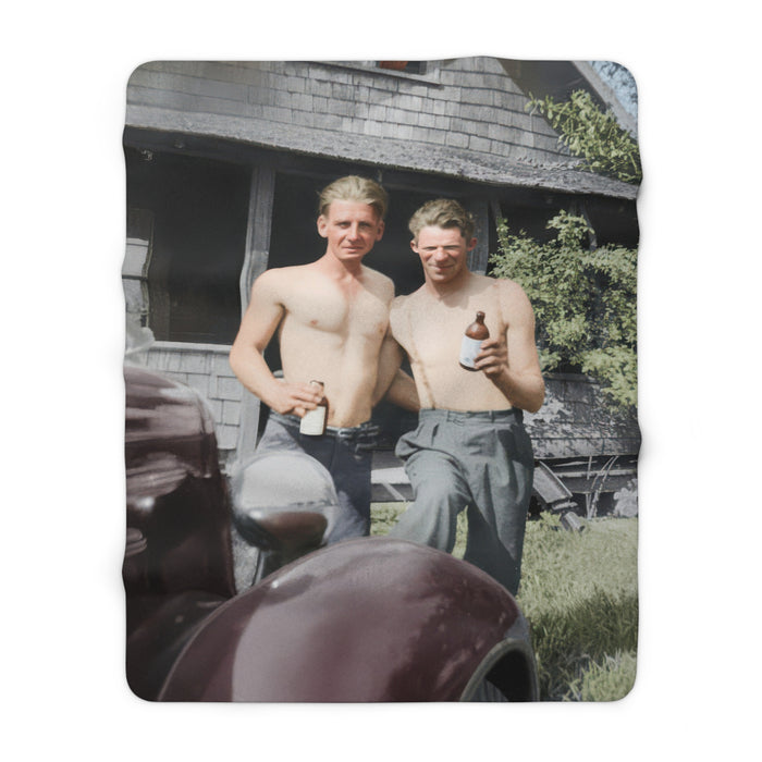Cozy fleece throw with vintage photograph beside a rustic house and early automobile