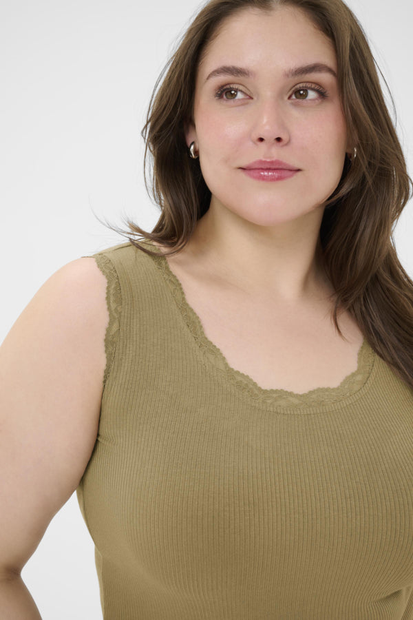 Woman wearing a green sleeveless top against a white background