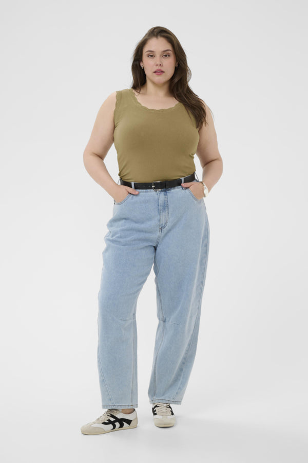 Person wearing a green tank top and light blue jeans on a white background