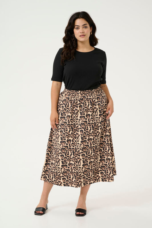 Woman wearing a black top and leopard print skirt on a white background