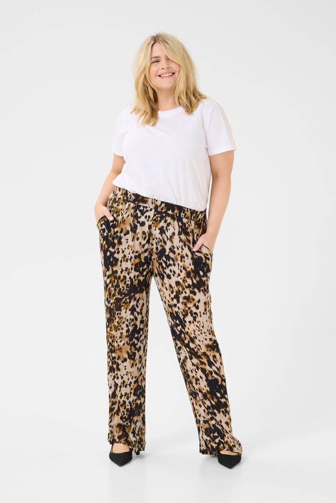 Woman wearing a white t-shirt and leopard print pants on a white background
