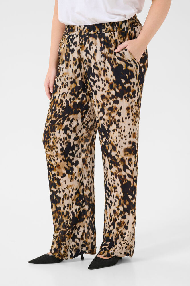 Leopard print pants worn by a person on a white background