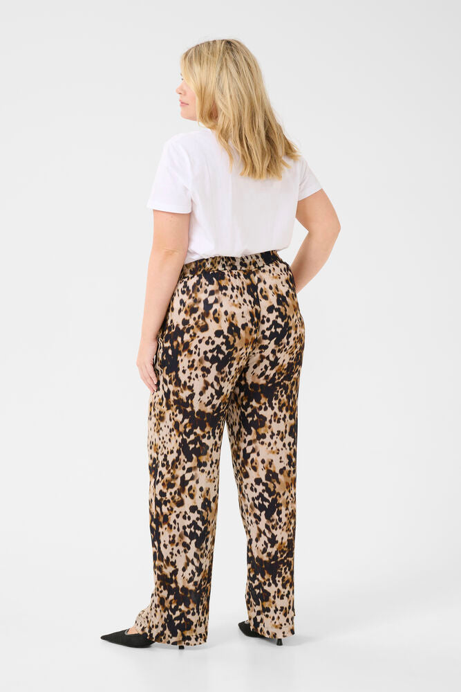 Woman wearing a white t-shirt and leopard print pants on a white background