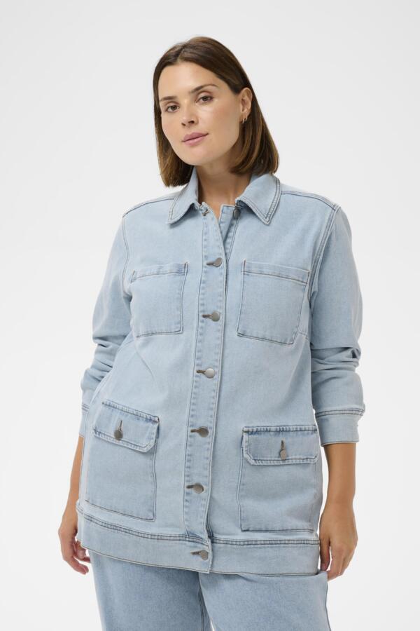 Woman wearing a light blue denim jacket on a white background