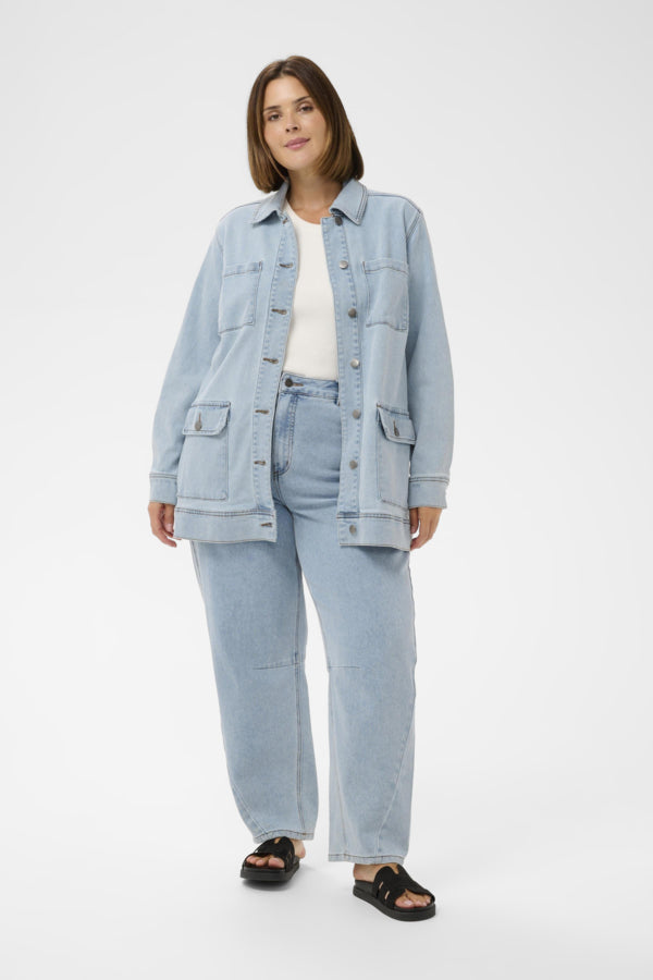 Woman wearing a light blue denim jacket and jeans on a white background