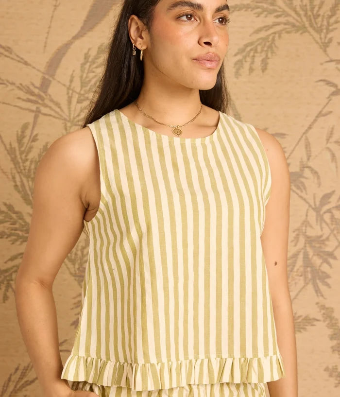 Woman wearing a yellow and white striped sleeveless top against a beige background