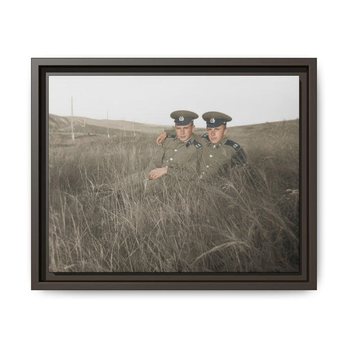 Vintage outdoor photograph of two uniformed sitters posed closely in a grassy landscape