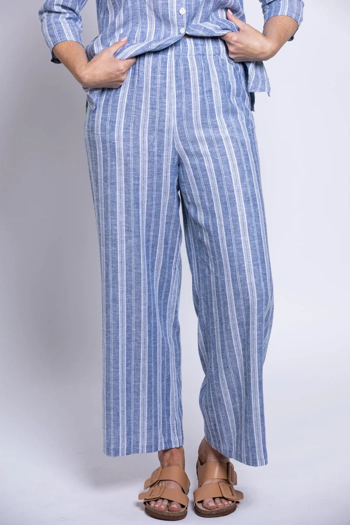 Person wearing a blue and white striped outfit with wide-leg pants on a plain background