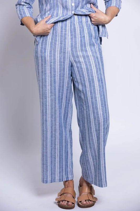 Person wearing a blue and white striped outfit with wide-leg pants on a plain background