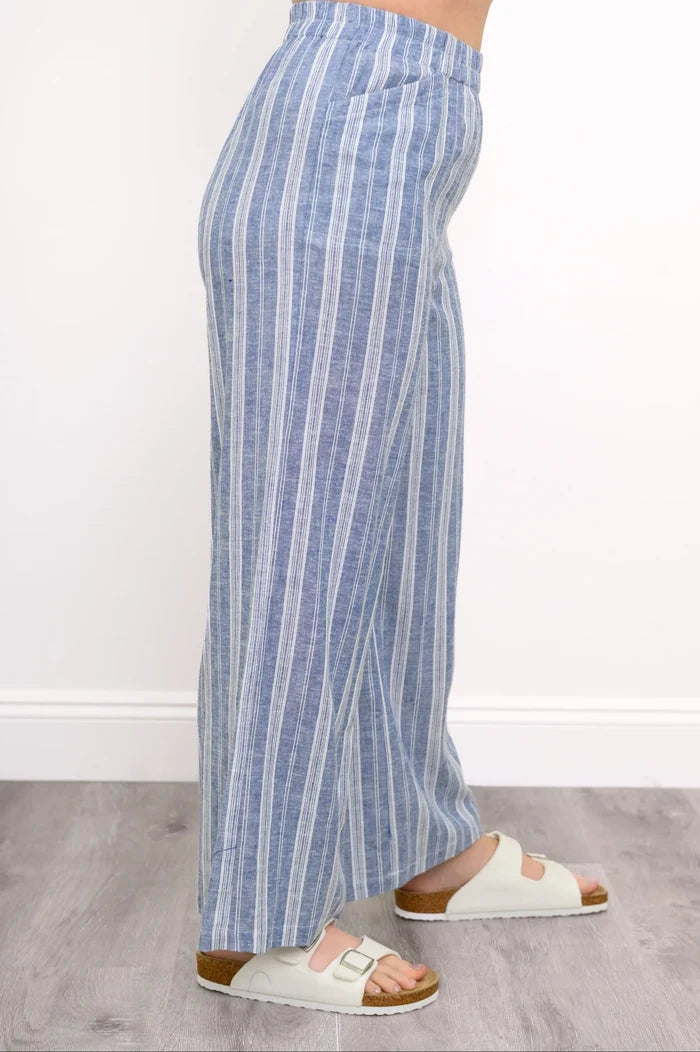 Blue and white striped pants worn by a person on a light gray floor.