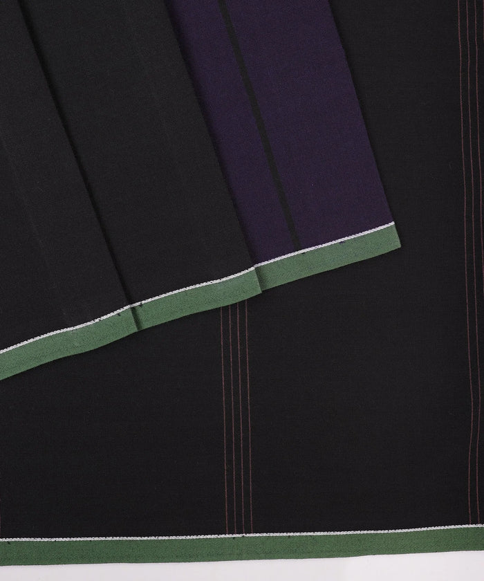 Close-up of a black fabric with green and purple trim