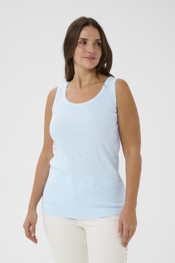Woman wearing a light blue sleeveless top with small patterns on a white background
