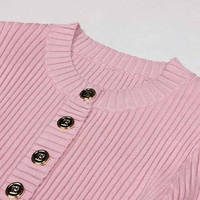 Close-up of a pink ribbed knit midi dress featuring decorative buttons on the front and a soft neckline