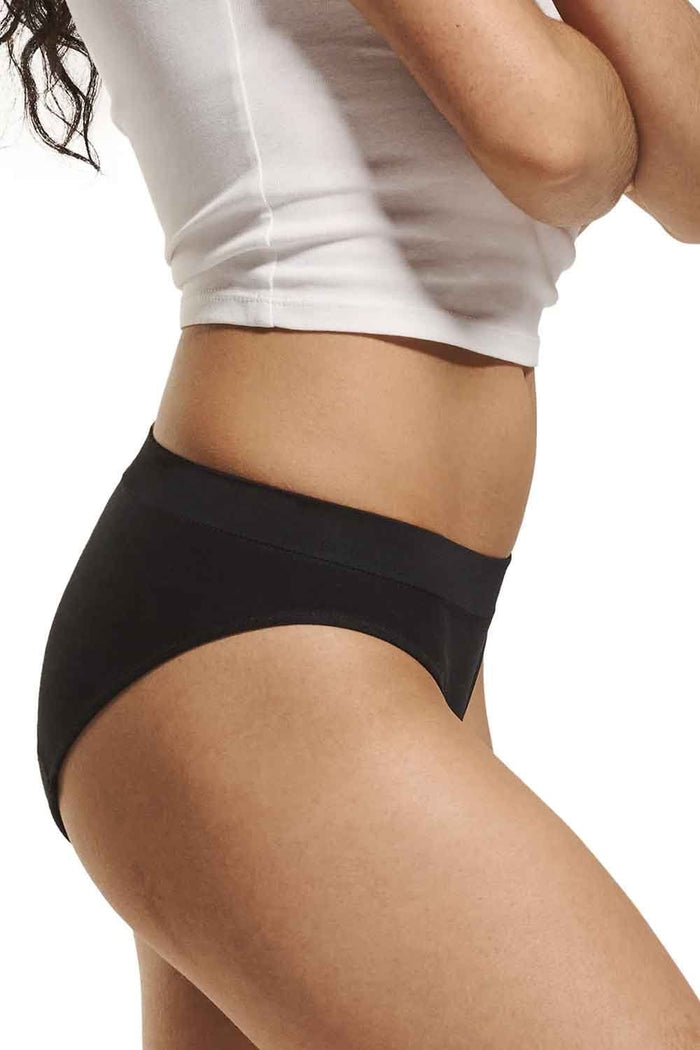 Person wearing love luna first teens seamfree period bikini brief and a white shirt on a plain background