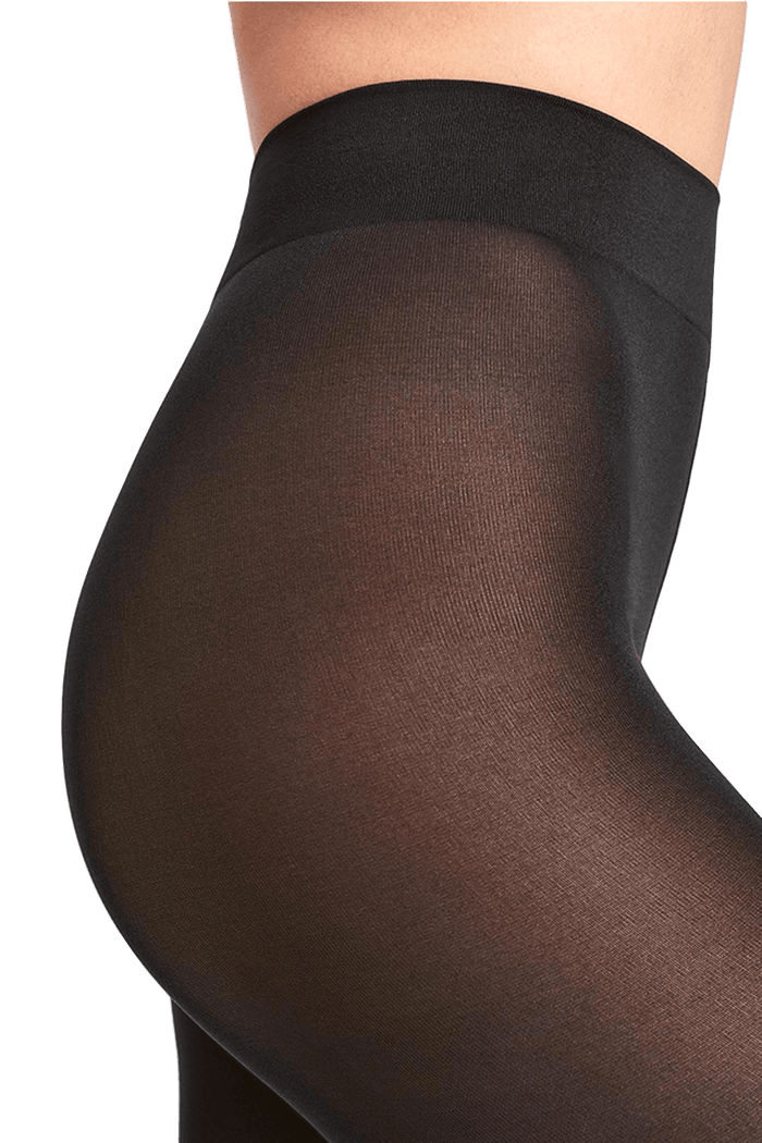 Black tights worn by a person on a black patterned background