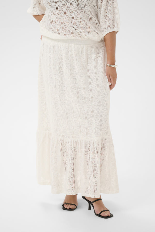 Person wearing a white lace top and skirt on a white background