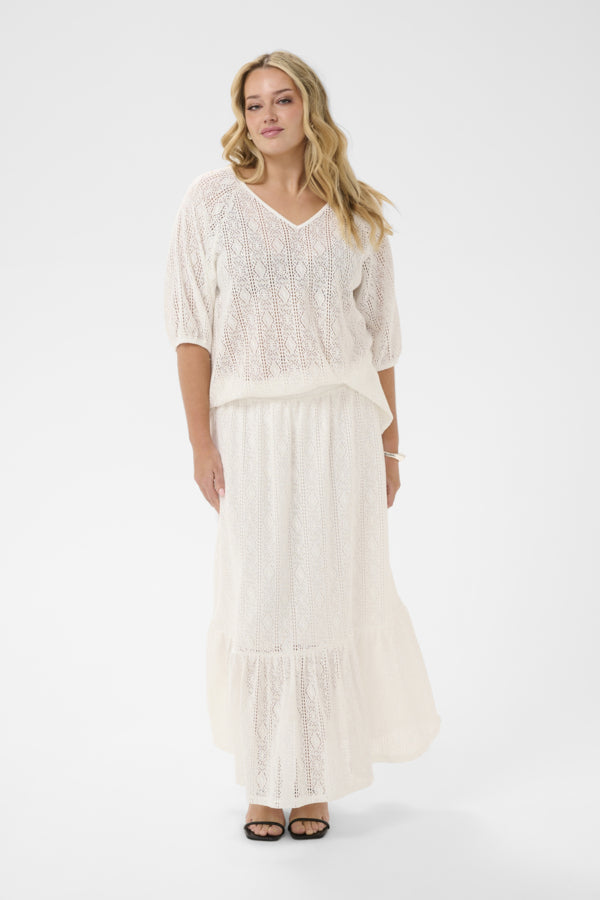 Woman wearing a white outfit with a plain background